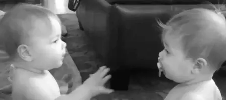Twin baby fight for a soother